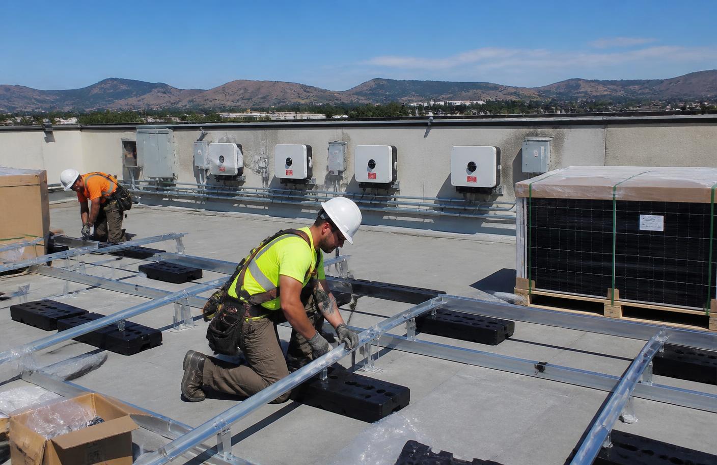 Installers setting ballasted racking for a 150 kW rooftop solar system in Kelowna, BC